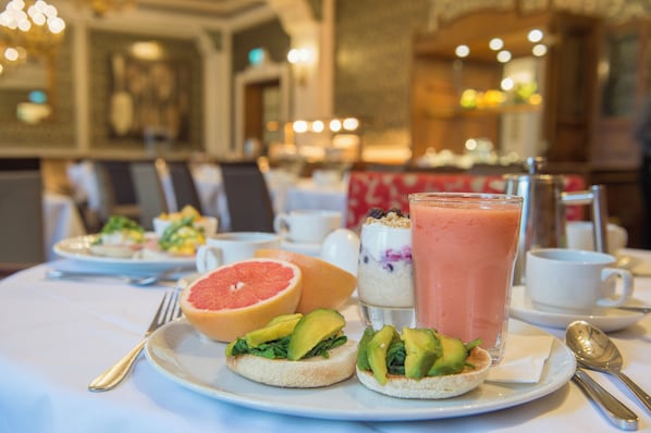 A breakfast setting with a plate of toast topped with avocado and greens, a grapefruit, and a glass of smoothie. - Crowne Plaza Royal Victoria Sheffield by IHG (Sheffield)