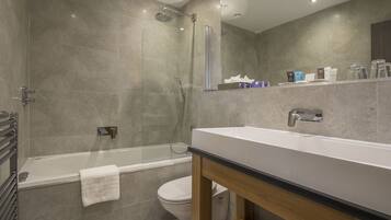 Un baño moderno con bañera, ducha e inodoro.