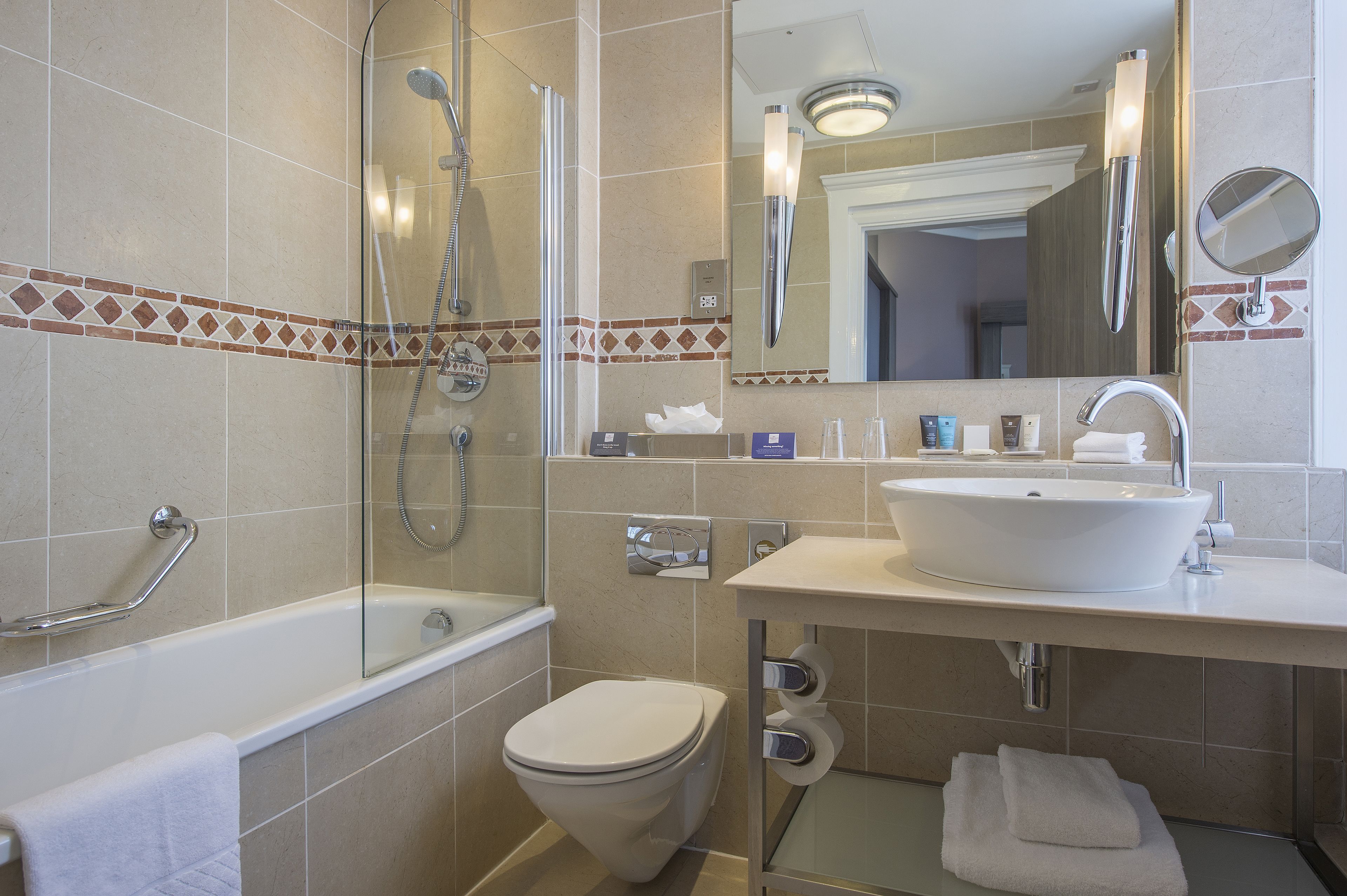 A modern bathroom with a bathtub, toilet, and sink.