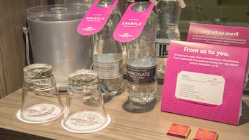 Presentación de botellas de agua y cristalería con etiquetas de hoteles Crowne Plaza.