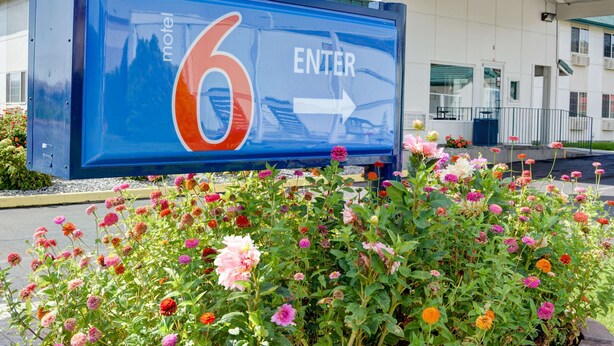 A motel sign with a large number '6' and an arrow pointing right, indicating the direction to enter. - Motel 6 The Dalles, OR (The Dalles)