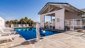 A swimming pool with lounge chairs, a lifeguard stand, and a covered seating area. - Motel 6 The Dalles, OR (The Dalles)