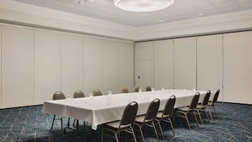 A conference room with a long table, chairs, and a door.
