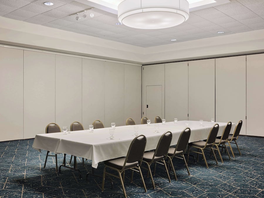 A conference room with a long table, chairs, and a door.
