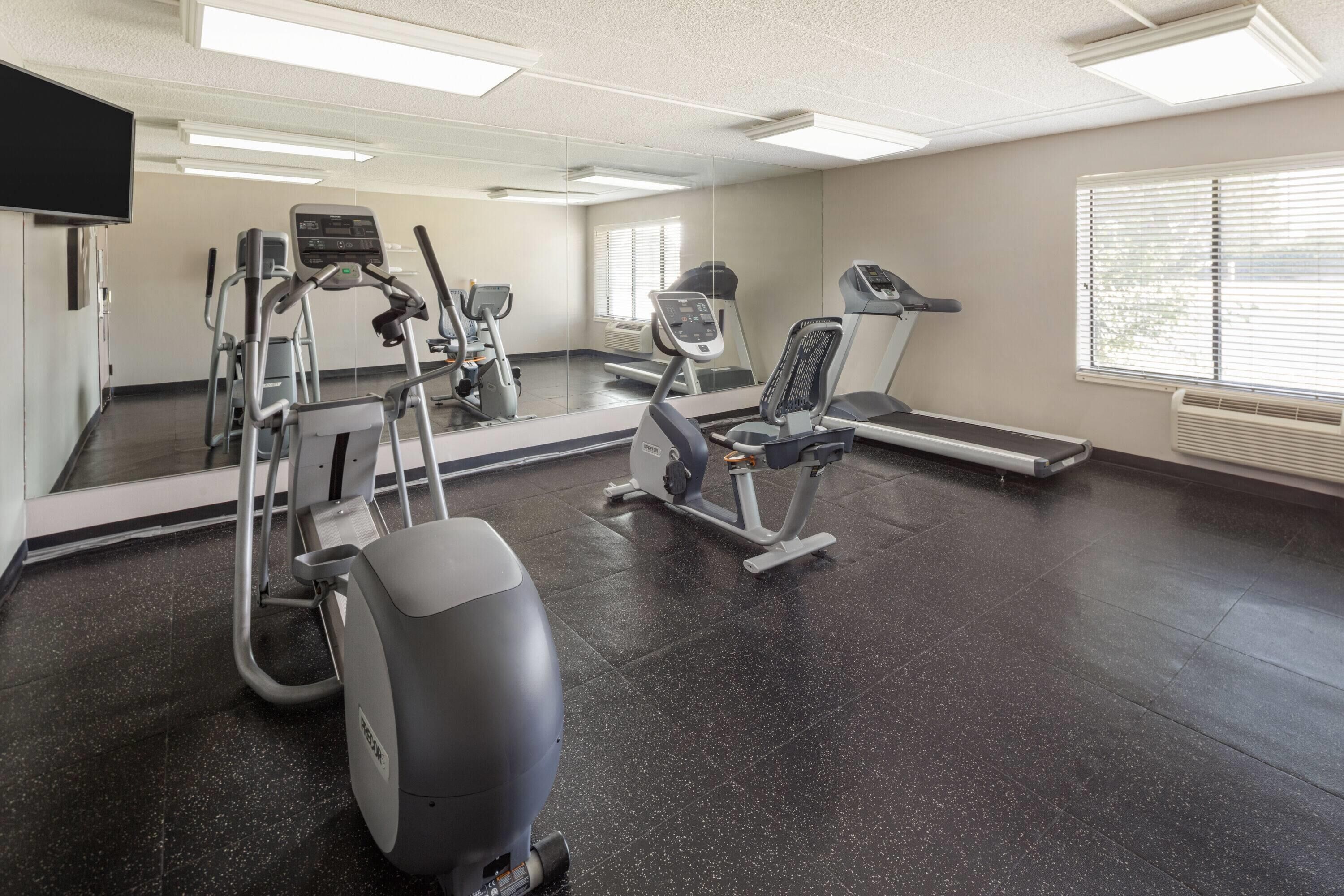 A fitness center with treadmills, elliptical machines, and a stationary bike.