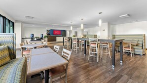 A modern hotel lobby with a dining area, a bar, and a kitchen in the background. - Allentown Park Hotel by The Red Collection (Allentown)