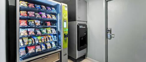 A vending machine with snacks and a refrigerator.