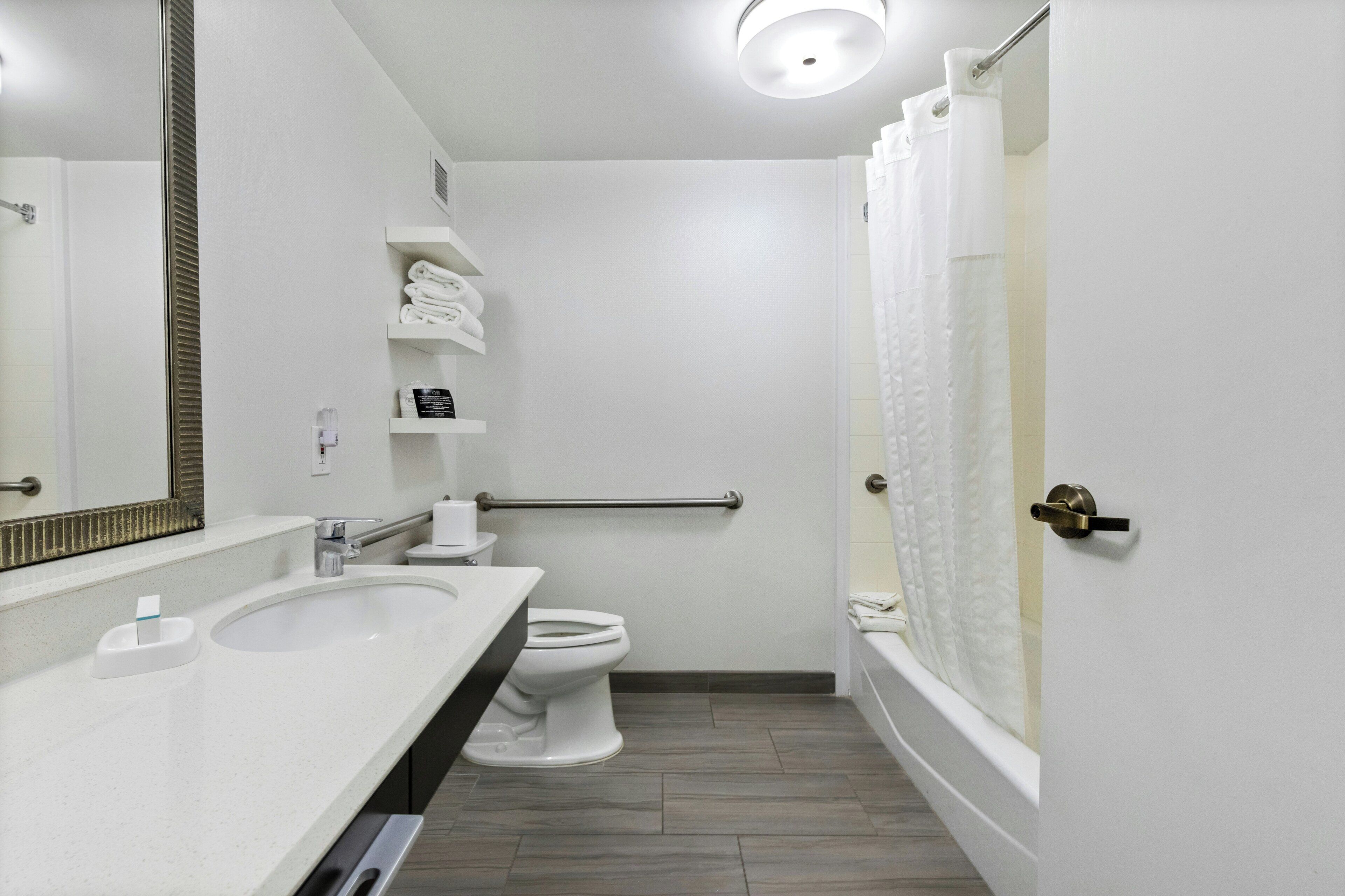 Un baño con lavamanos, inodoro y ducha.
