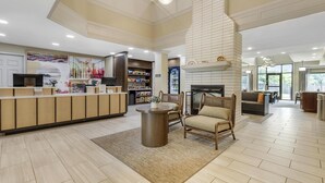 A spacious lobby with a reception desk, seating area, and a fireplace.