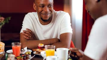 Une table à manger avec des aliments pour le petit-déjeuner, notamment des toasts, des œufs et des fruits.