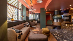Un intérieur moderne avec un canapé, un pouf et une table ronde.
