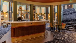 Un espace bar avec un comptoir, des sièges et un escalier.