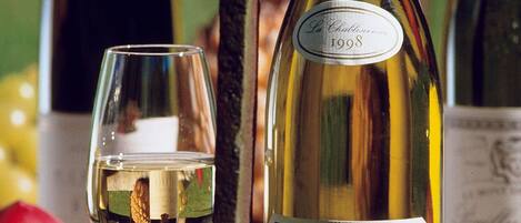 Une bouteille de vin La Chablisienne, millésime 1998, et un verre à vin.