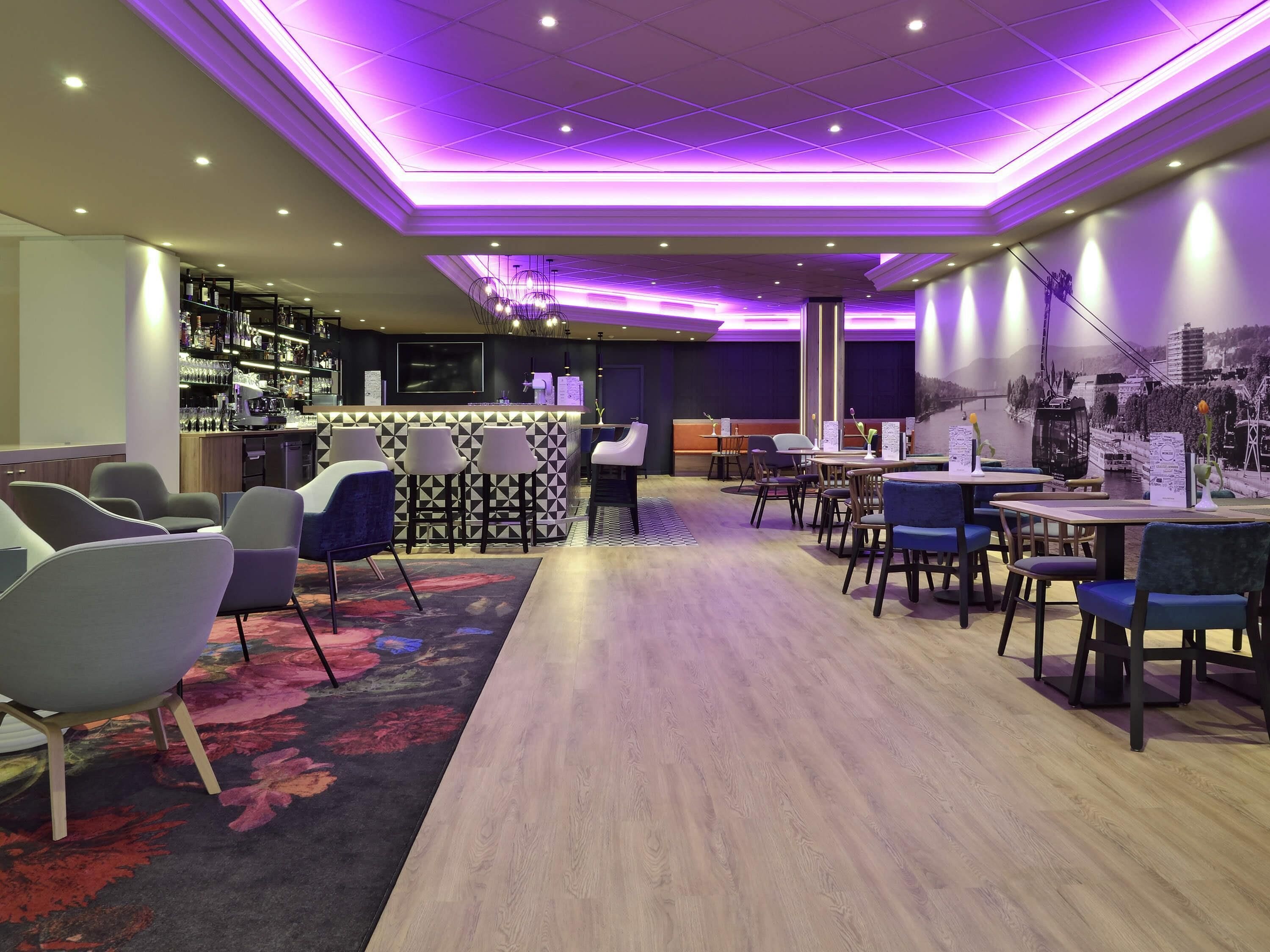 A modern bar area with seating and a view of a cityscape.