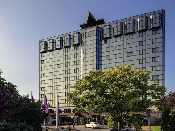 A modern hotel with a glass facade, a prominent entrance, and a parking area. - Mercure Hotel Koblenz (Koblenz)