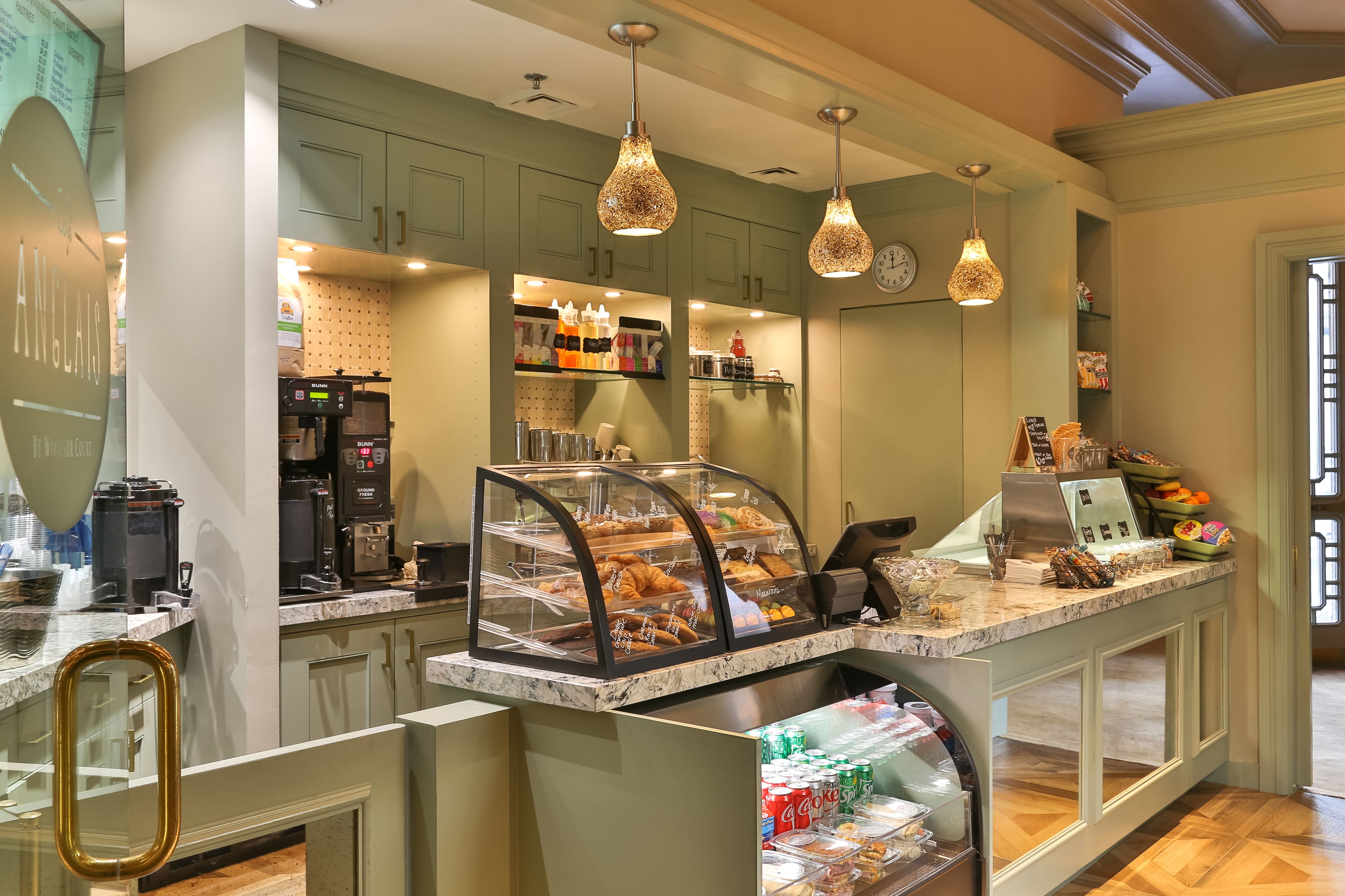 A bakery counter with a display case, coffee machines, and a variety of baked goods.
