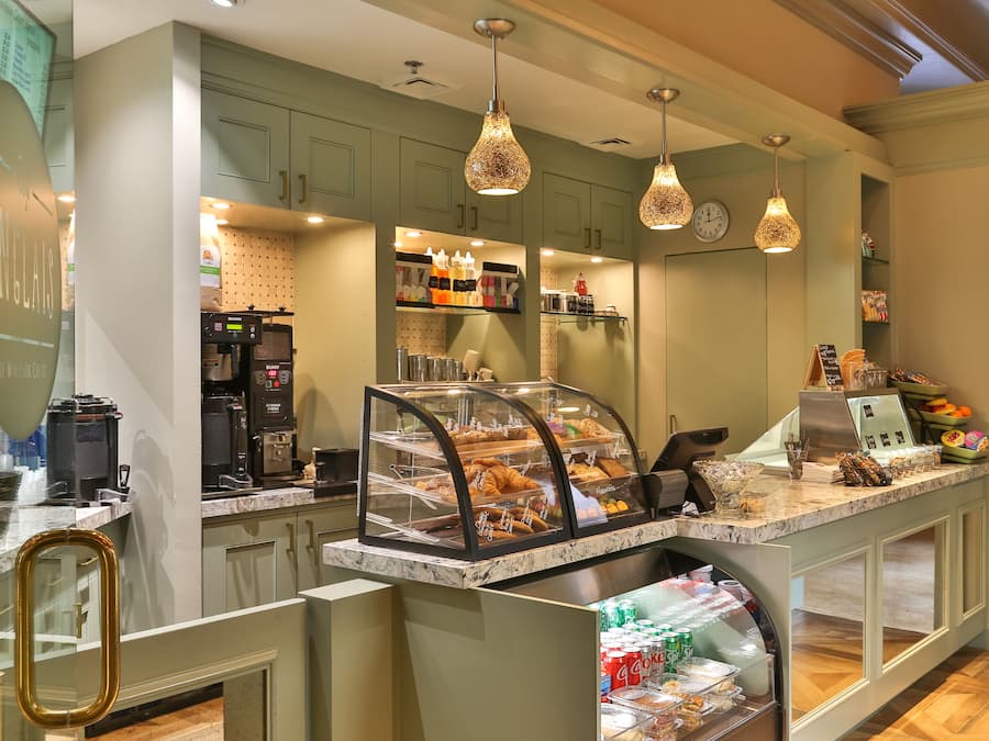 A bakery counter with a display case, coffee machines, and a variety of baked goods.