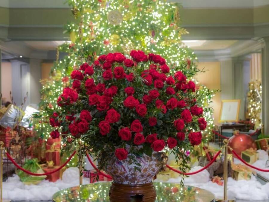 A large floral arrangement in a decorative vase, surrounded by red ropes and white foam.