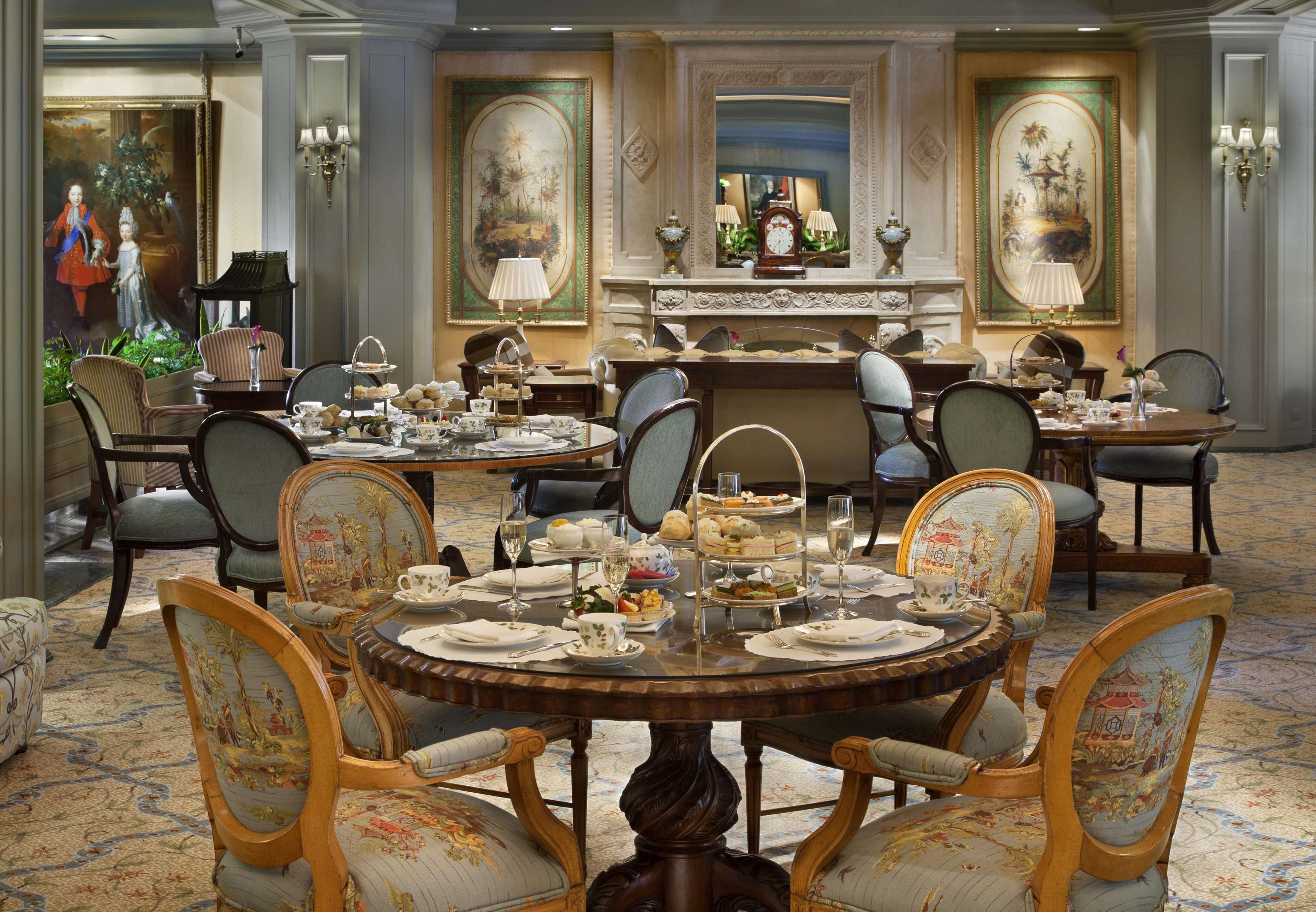 A formal dining room with ornate furniture, a chandelier, and a large mirror.