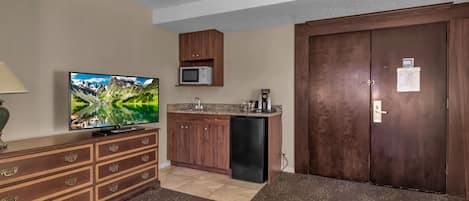 Eine moderne Küche mit eingebauter Mikrowelle, einer Kaffeemaschine und einem Kühlschrank.