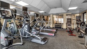 A gym with treadmills, elliptical machines, and weightlifting equipment.