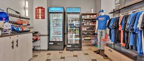 A retail store interior with a mannequin, shelves stocked with various items, and two refrigerated display cases.