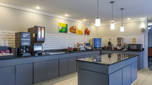 Una cocina moderna con una isla central, electrodomésticos integrados y un piso de baldosas impecable.