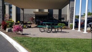 Un espace extérieur abrité comprenant une table de billard, des sièges et un mât pour drapeau.