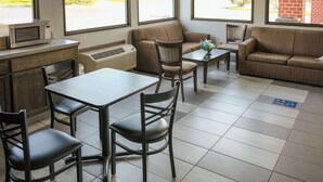 Ein modernes Interieur mit einem Esstisch, Stühlen, einer Couch und einer Mikrowelle auf einer Arbeitsfläche.