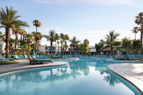 A swimming pool with lounge chairs and palm trees. - Riviera Resort Palm Springs (Palm Springs)