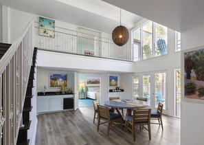 A spacious dining area with a high ceiling, a staircase, and a view of the outdoors. - Riviera Resort Palm Springs (Palm Springs)