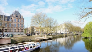 Un canal con un bote, un puente y un edificio histórico.