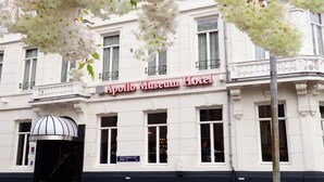 Fachada del Hotel Museo Apollo con arquitectura clásica, ventanas grandes y un letrero.