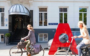 A building with a prominent dome entrance, a sign reading "PIETER CORNELIS HOFT" and "Museumkwater ZUID," and a red A-shaped structure on the sidewalk. - Leonardo Hotel Amsterdam Museum Quarter (Amsterdam)