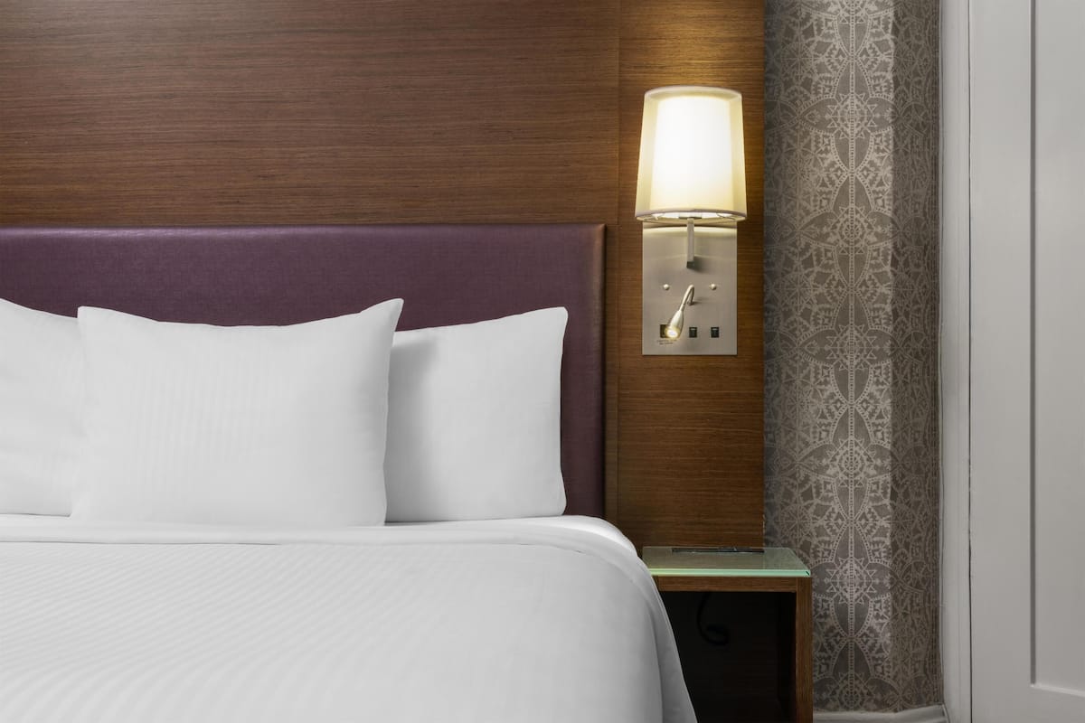 Roupas de cama premium, escrivaninha, espaço de trabalho para notebook