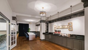 A modern kitchen with dark cabinets, a central island, and pendant lighting. - The Cartwright Hotel - Union Square BW Premier Collection (San Francisco)