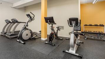 A gym with stationary bikes, treadmills, and weight machines.