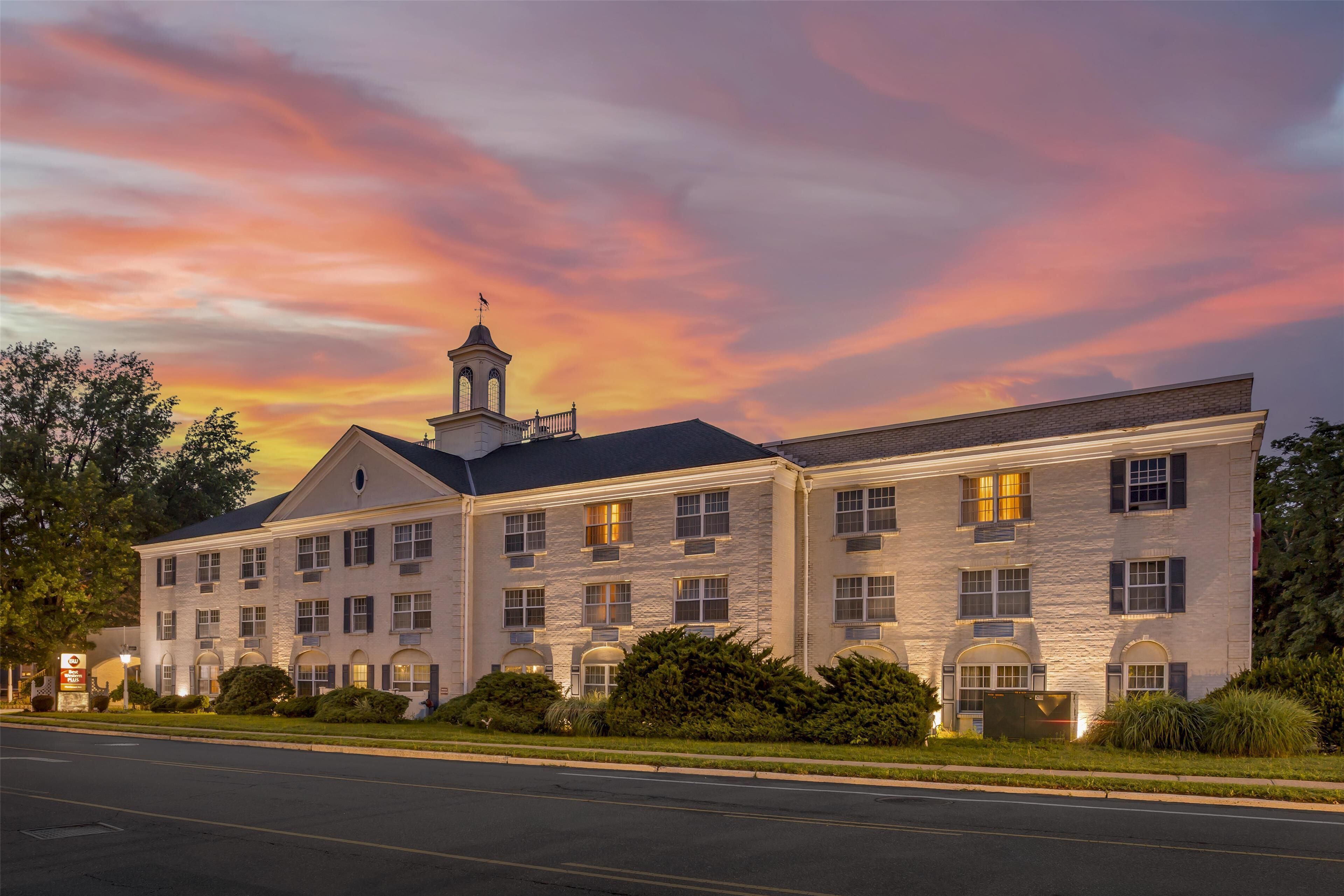 A large, multi-story hotel with a classic architectural style, featuring a prominent tower and symmetrical windows.
