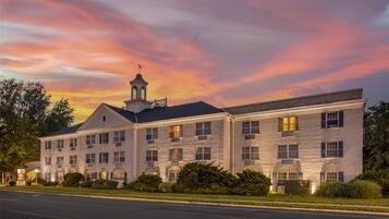 A large, multi-story hotel with a classic architectural style, featuring a prominent tower and symmetrical windows.