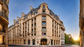 Un bâtiment historique doté d’une façade incurvée, de nombreux balcons et d’une entrée imposante.