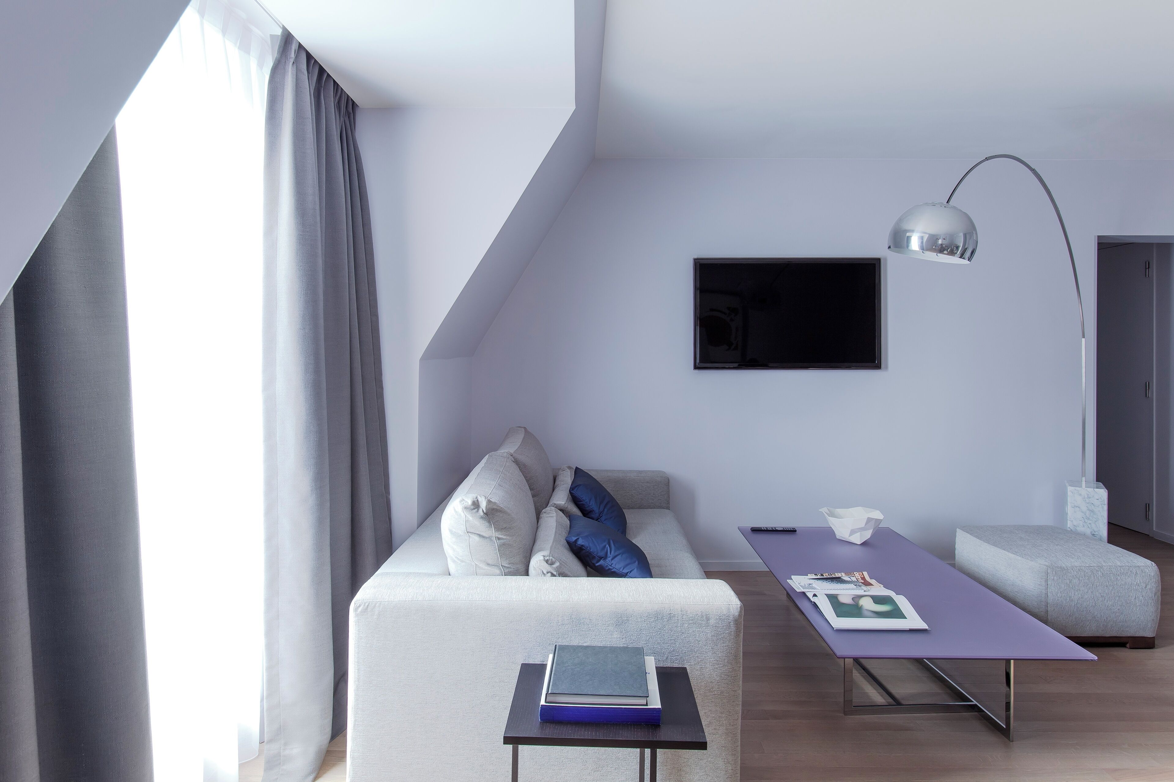 Una sala de estar moderna con un sofá, una mesa y una lámpara.