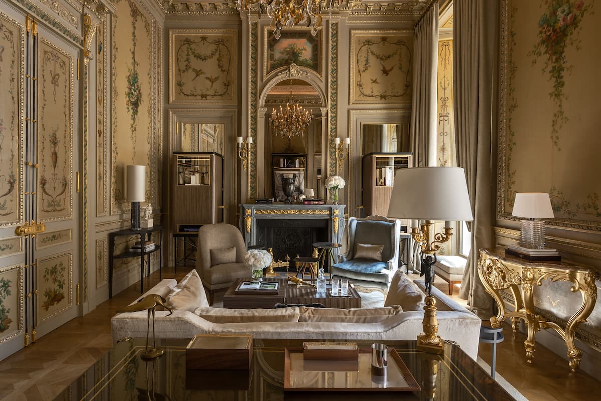 Une chambre luxueuse, dotée d’un décor raffiné, d’une cheminée et de meubles élégants.
