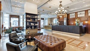 Un vestíbulo amplio con asientos de cuero, una zona de bar y un candelabro.