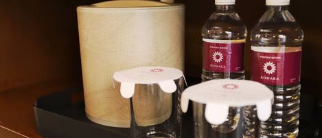 A tray with a candle, two glass bottles, and a metal container.