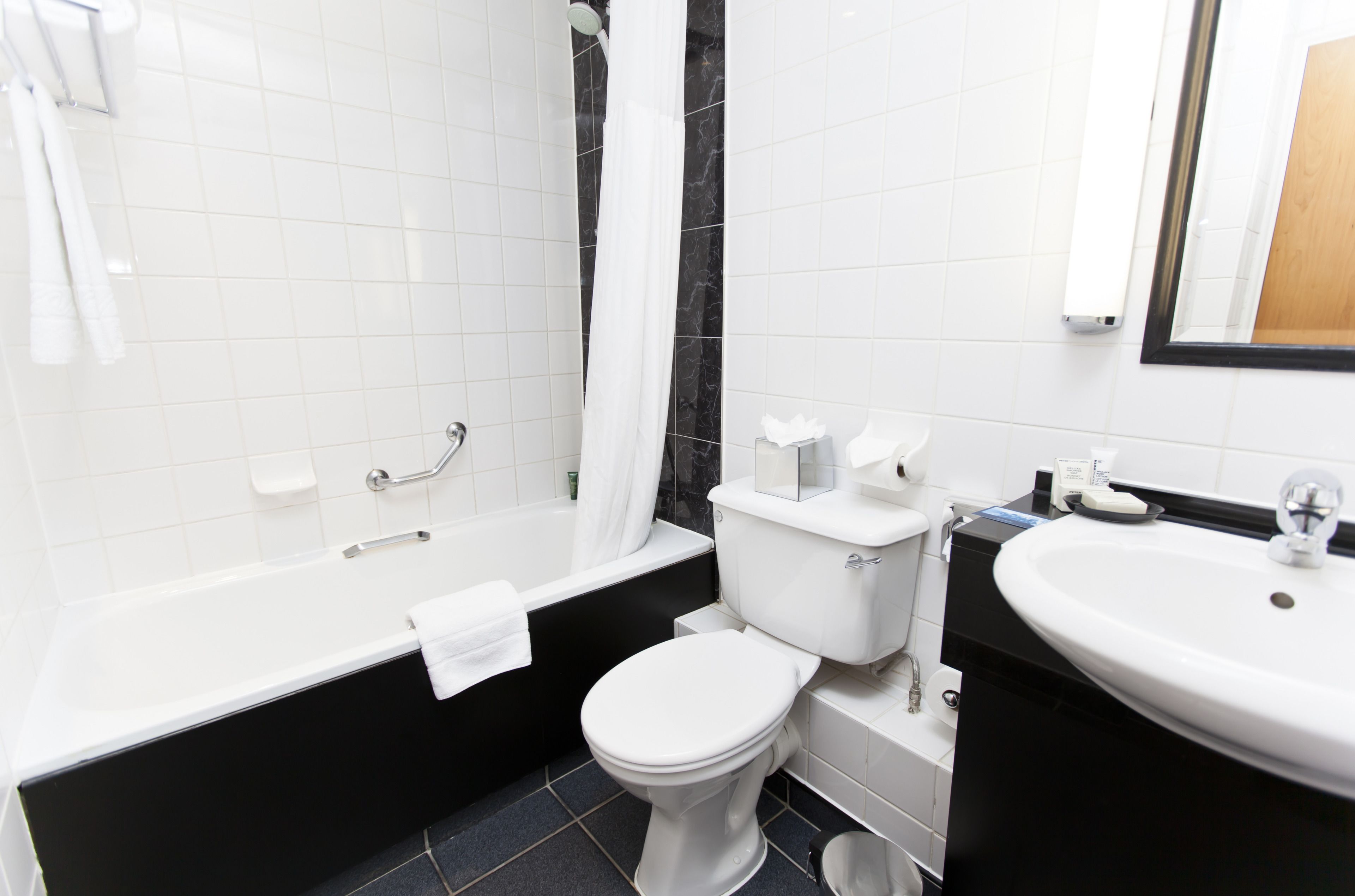 Un baño moderno con una bañera blanca, un inodoro y un lavabo.