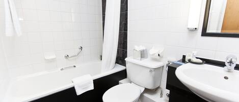 Un baño moderno con una bañera blanca, un inodoro y un lavabo.