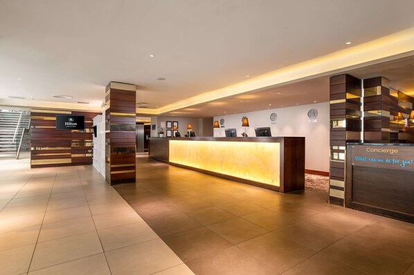 Welcome to the Hilton reception area, where a sleek design and warm glow create a contemporary ambiance.