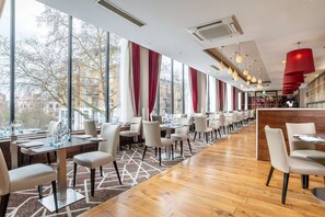 Enjoy dining in this spacious restaurant with a high ceiling and city views.