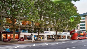 A street with a Costa Coffee, a Hilton hotel, and a red double-decker bus. - Hilton London Olympia (London)