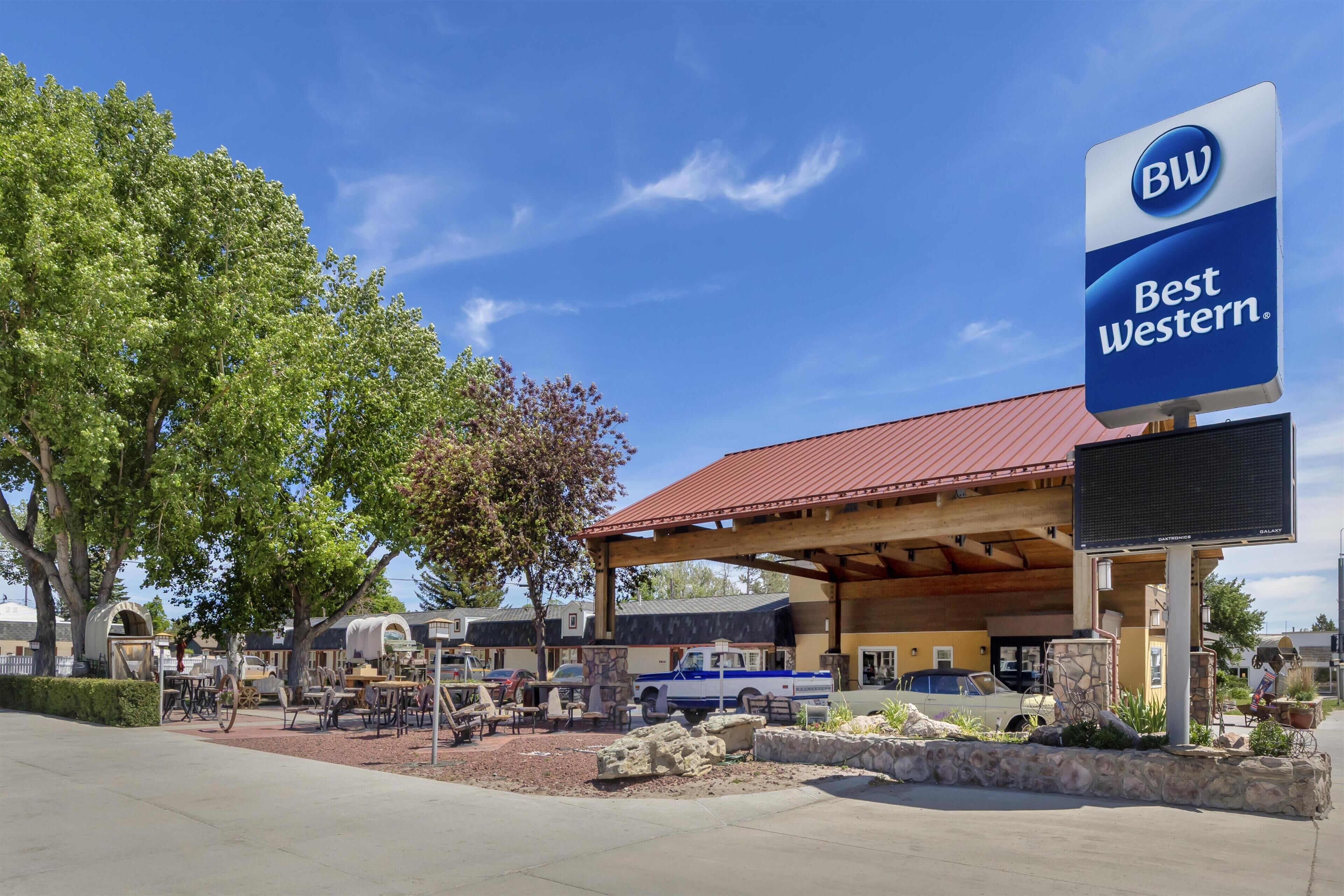 A Best Western hotel with outdoor seating, a covered area, and a signboard.